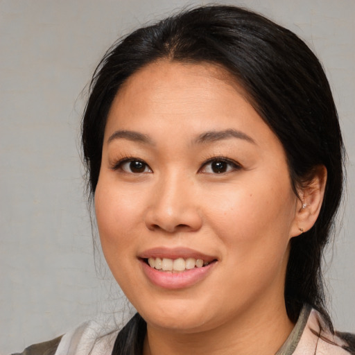 Joyful asian young-adult female with medium  brown hair and brown eyes