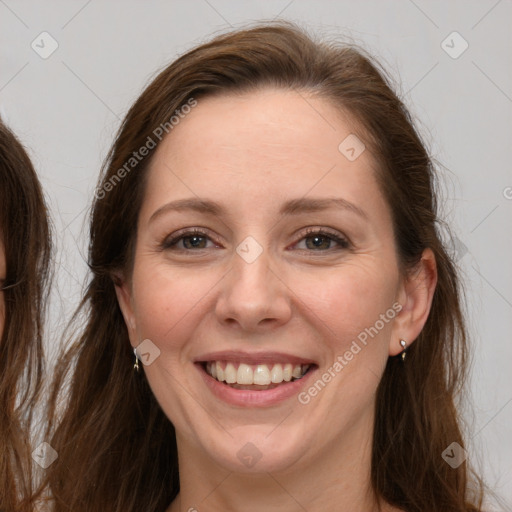 Joyful white adult female with long  brown hair and grey eyes