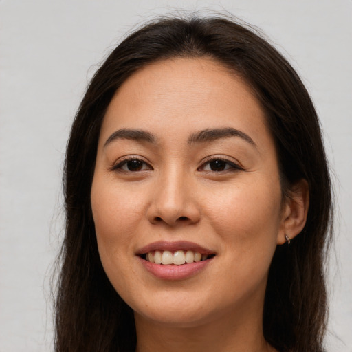 Joyful asian young-adult female with long  brown hair and brown eyes