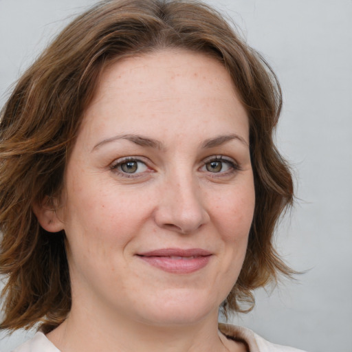 Joyful white young-adult female with medium  brown hair and blue eyes