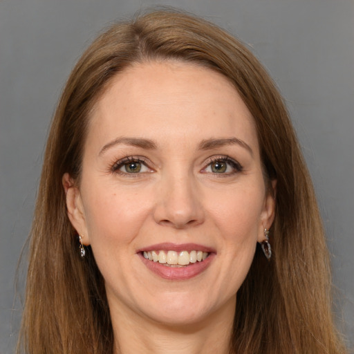 Joyful white adult female with long  brown hair and grey eyes