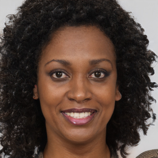 Joyful black young-adult female with medium  brown hair and brown eyes
