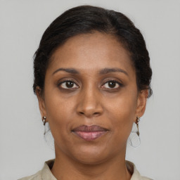 Joyful black adult female with medium  brown hair and brown eyes