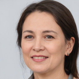 Joyful white adult female with medium  brown hair and brown eyes