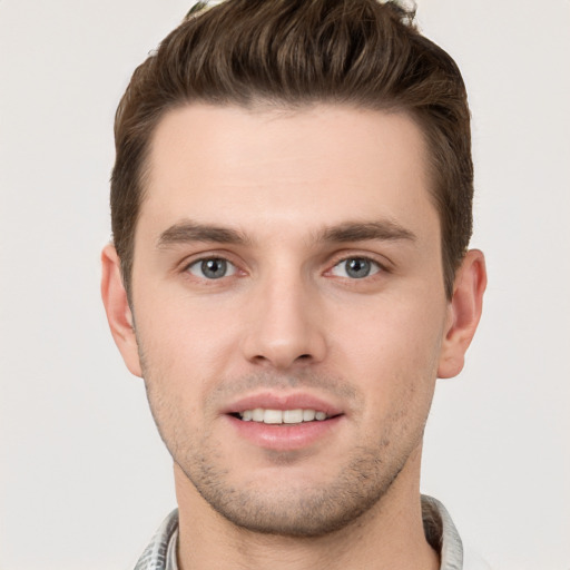 Joyful white young-adult male with short  brown hair and grey eyes