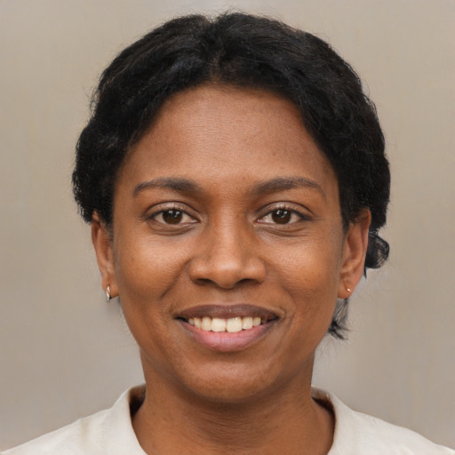 Joyful black young-adult female with short  black hair and brown eyes