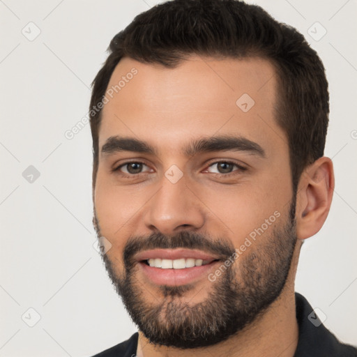 Joyful white young-adult male with short  black hair and brown eyes