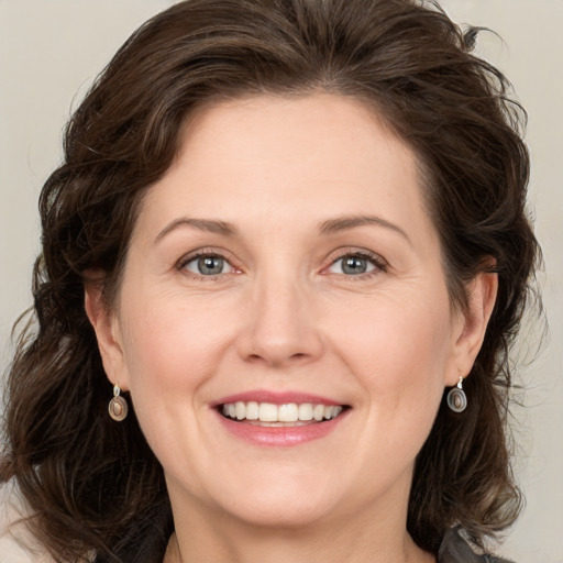 Joyful white adult female with medium  brown hair and grey eyes