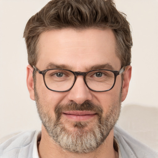 Joyful white adult male with short  brown hair and green eyes