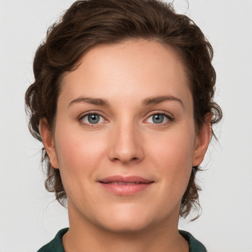 Joyful white young-adult female with medium  brown hair and green eyes