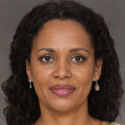 Joyful black adult female with long  brown hair and brown eyes
