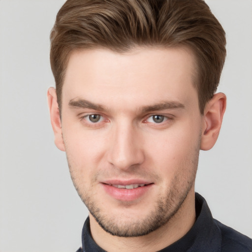 Joyful white young-adult male with short  brown hair and grey eyes