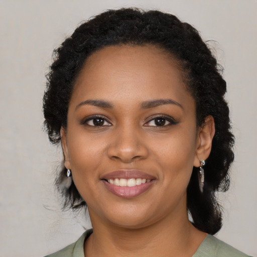Joyful black young-adult female with medium  brown hair and brown eyes