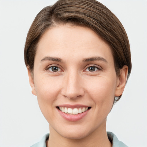 Joyful white young-adult female with short  brown hair and grey eyes