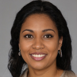 Joyful black young-adult female with long  brown hair and brown eyes