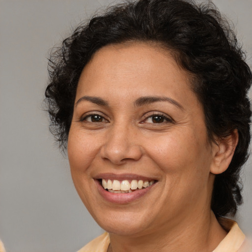 Joyful latino adult female with medium  brown hair and brown eyes