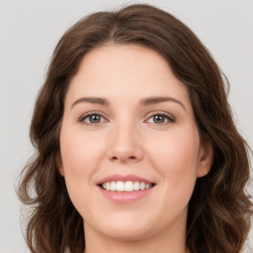 Joyful white young-adult female with long  brown hair and green eyes