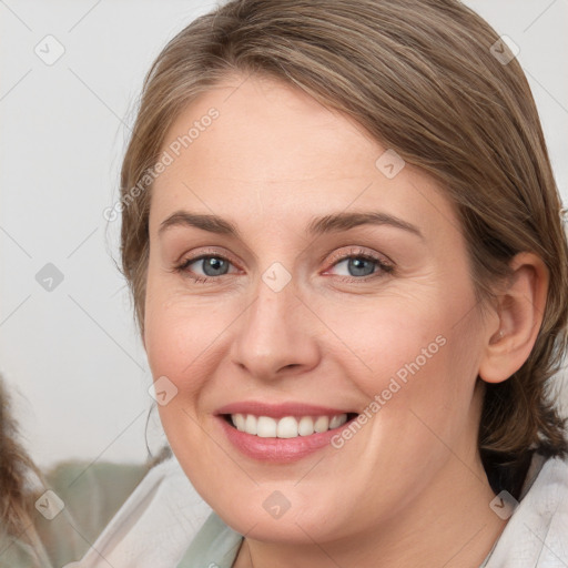 Joyful white young-adult female with medium  brown hair and blue eyes