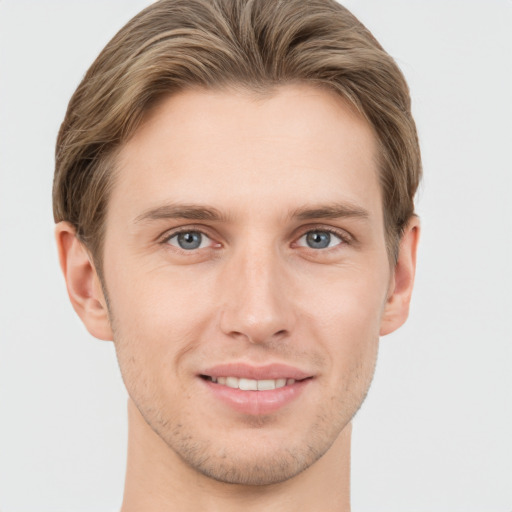 Joyful white young-adult male with short  brown hair and grey eyes