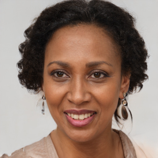 Joyful black adult female with long  brown hair and brown eyes