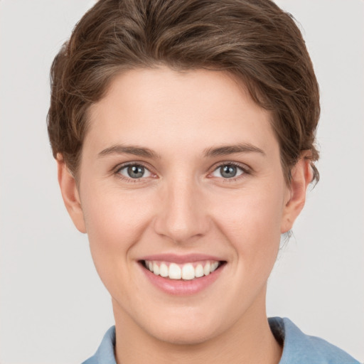 Joyful white young-adult female with short  brown hair and grey eyes