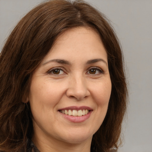 Joyful white adult female with long  brown hair and brown eyes