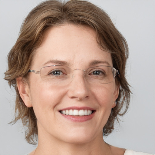 Joyful white adult female with medium  brown hair and grey eyes