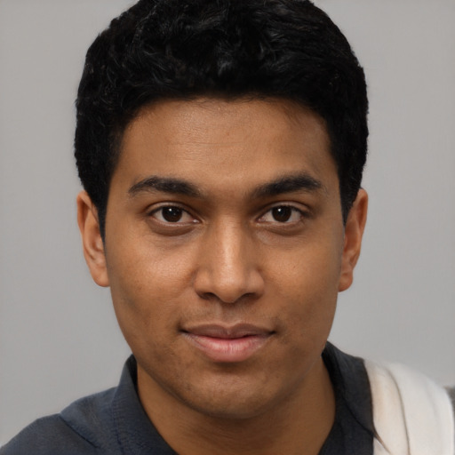 Joyful black young-adult male with short  black hair and brown eyes