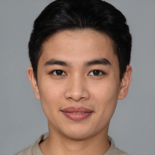 Joyful asian young-adult male with short  brown hair and brown eyes