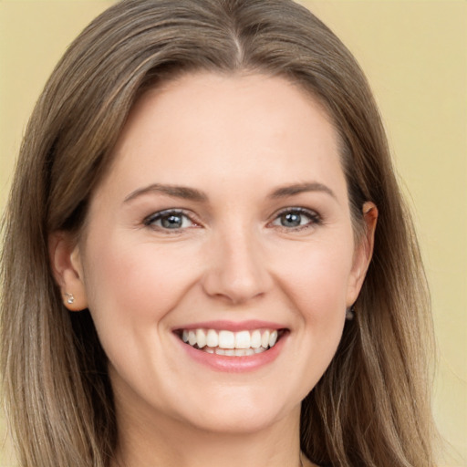 Joyful white young-adult female with long  brown hair and green eyes