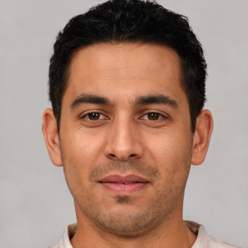 Joyful white young-adult male with short  black hair and brown eyes