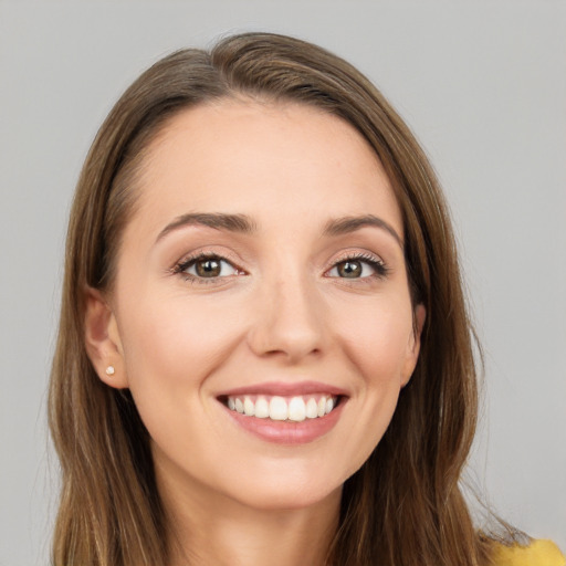 Joyful white young-adult female with long  brown hair and brown eyes