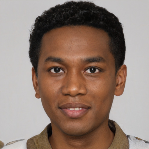 Joyful black young-adult male with short  black hair and brown eyes