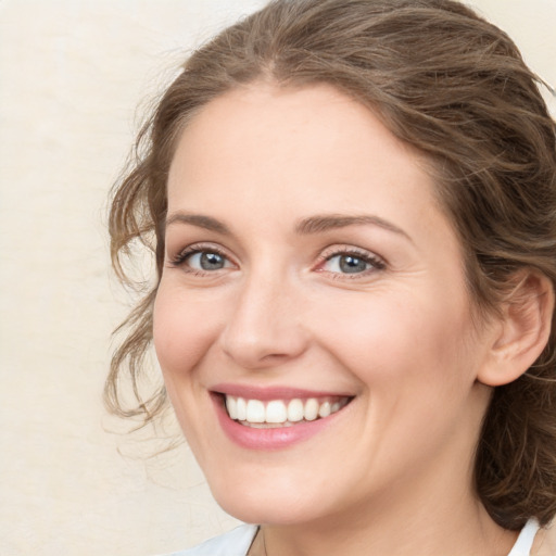 Joyful white young-adult female with medium  brown hair and green eyes