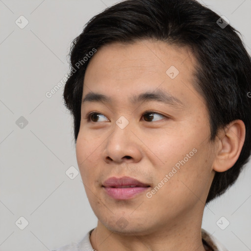 Joyful asian young-adult male with short  brown hair and brown eyes