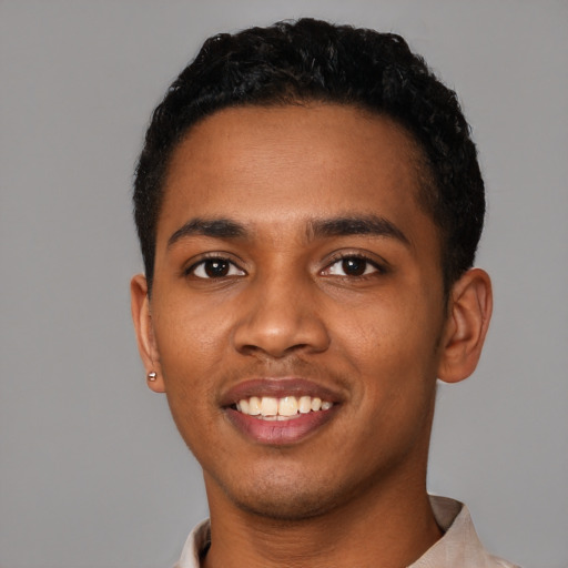 Joyful black young-adult male with short  black hair and brown eyes