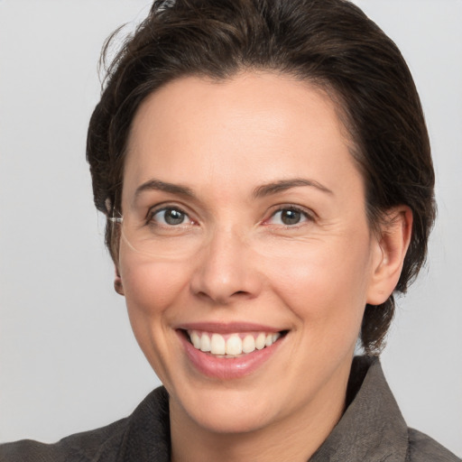 Joyful white adult female with medium  brown hair and grey eyes