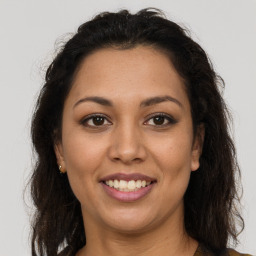 Joyful latino young-adult female with long  brown hair and brown eyes