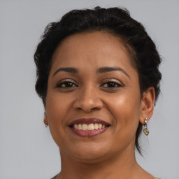 Joyful latino young-adult female with short  black hair and brown eyes