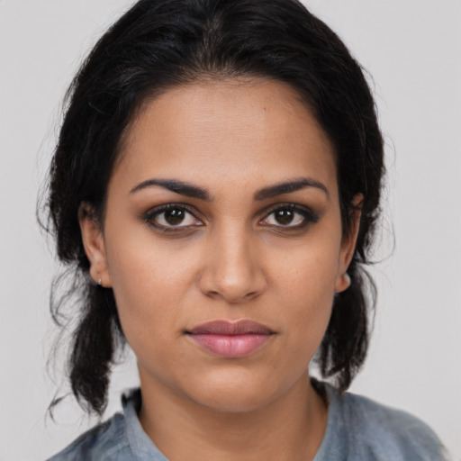 Joyful latino young-adult female with medium  brown hair and brown eyes