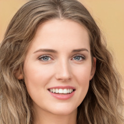 Joyful white young-adult female with long  brown hair and green eyes