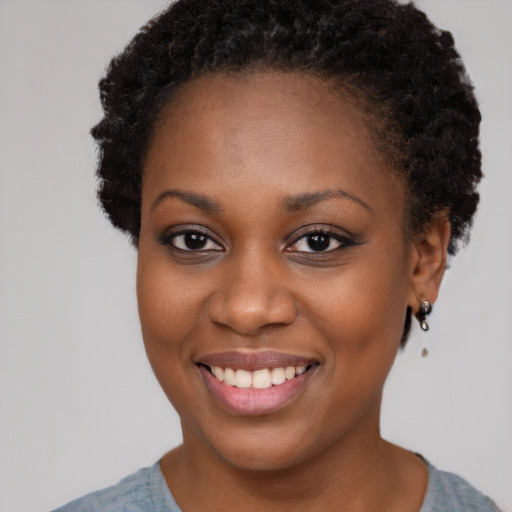 Joyful black young-adult female with short  brown hair and brown eyes