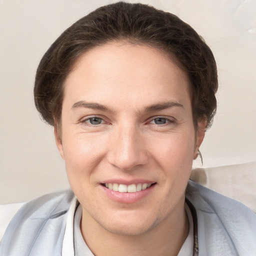 Joyful white young-adult female with short  brown hair and grey eyes