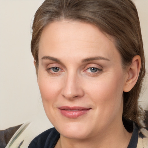 Joyful white adult female with medium  brown hair and grey eyes