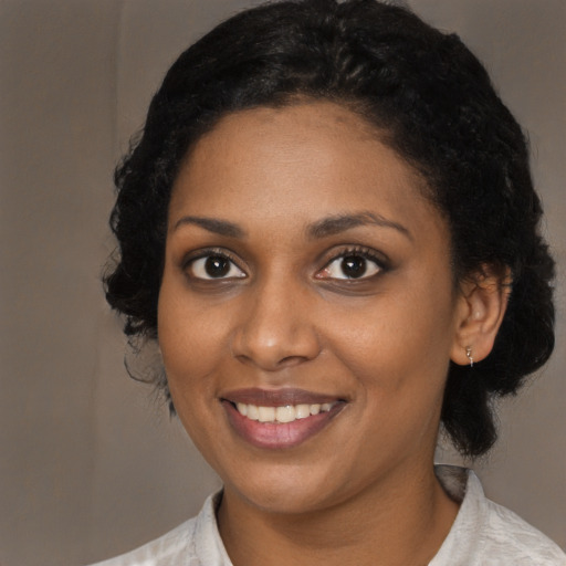 Joyful black young-adult female with medium  black hair and brown eyes
