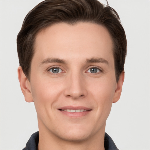 Joyful white young-adult male with short  brown hair and grey eyes