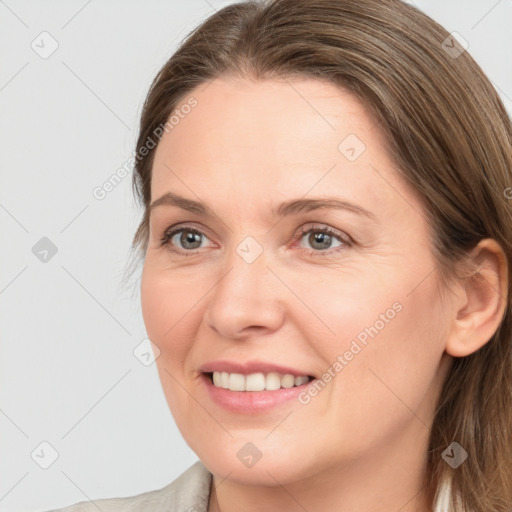 Joyful white adult female with long  brown hair and grey eyes