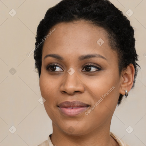 Joyful black young-adult female with short  black hair and brown eyes