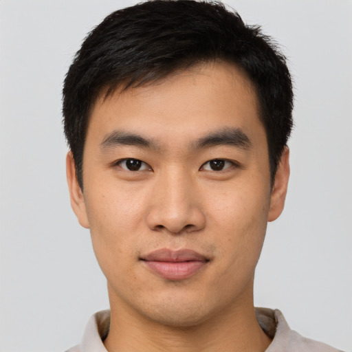 Joyful asian young-adult male with short  black hair and brown eyes