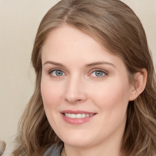 Joyful white young-adult female with long  brown hair and blue eyes